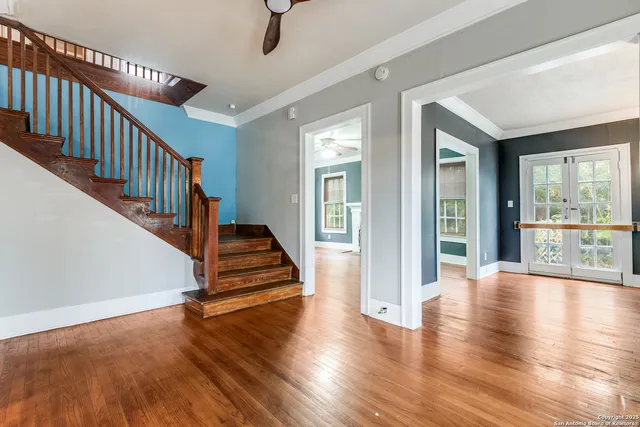 a view of a livingroom with wooden floor staircase and windows