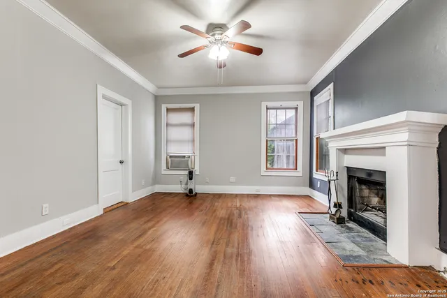 a view of empty room with wooden floor and fireplace