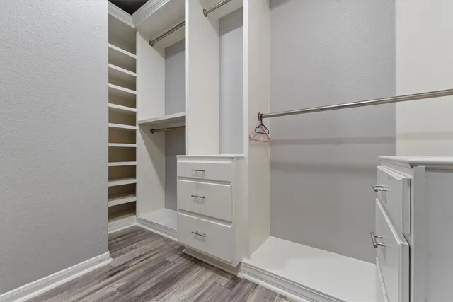 a view of walk in closet with empty racks