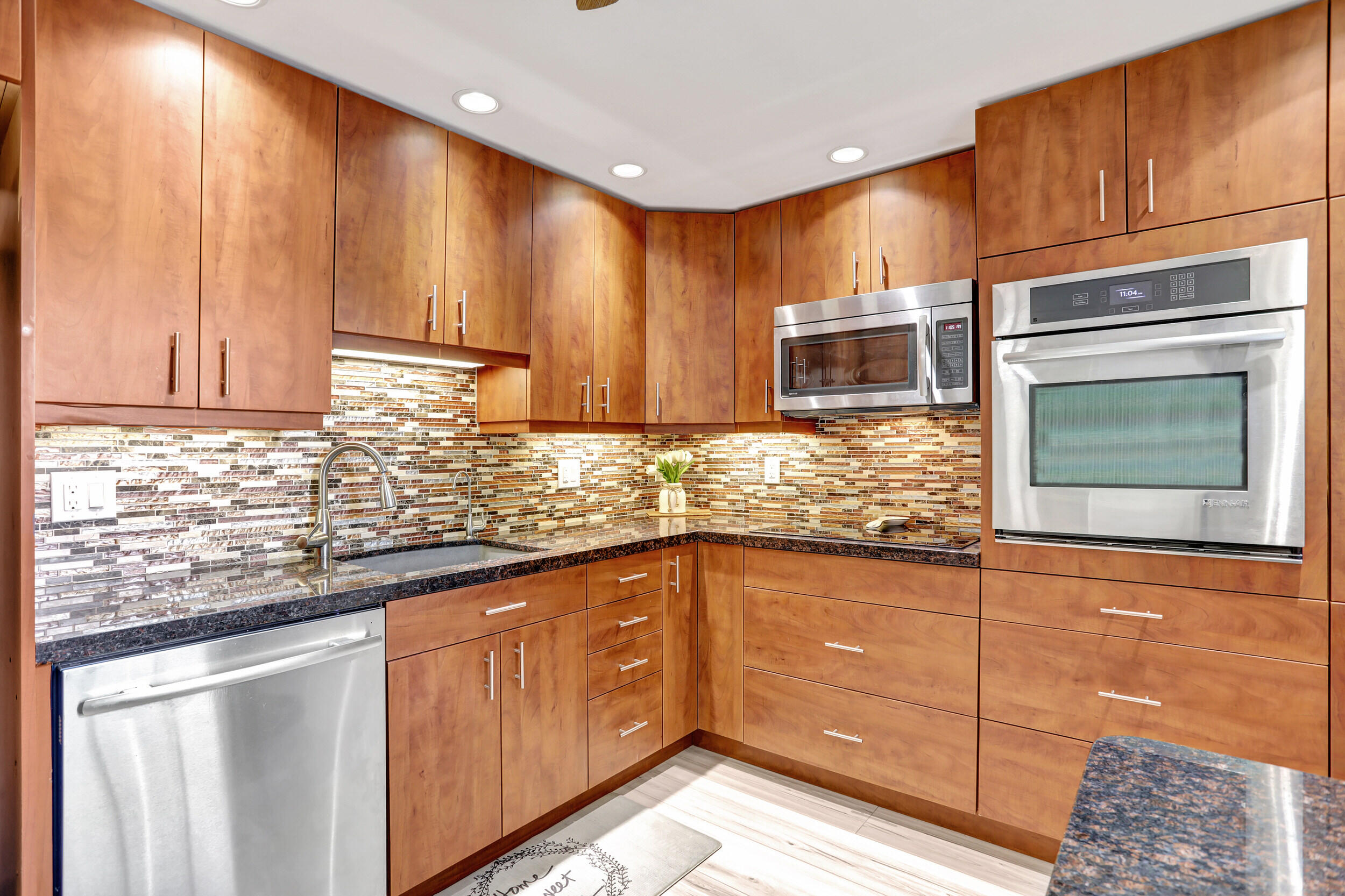 a kitchen with stainless steel appliances granite countertop wooden cabinets a stove and a sink
