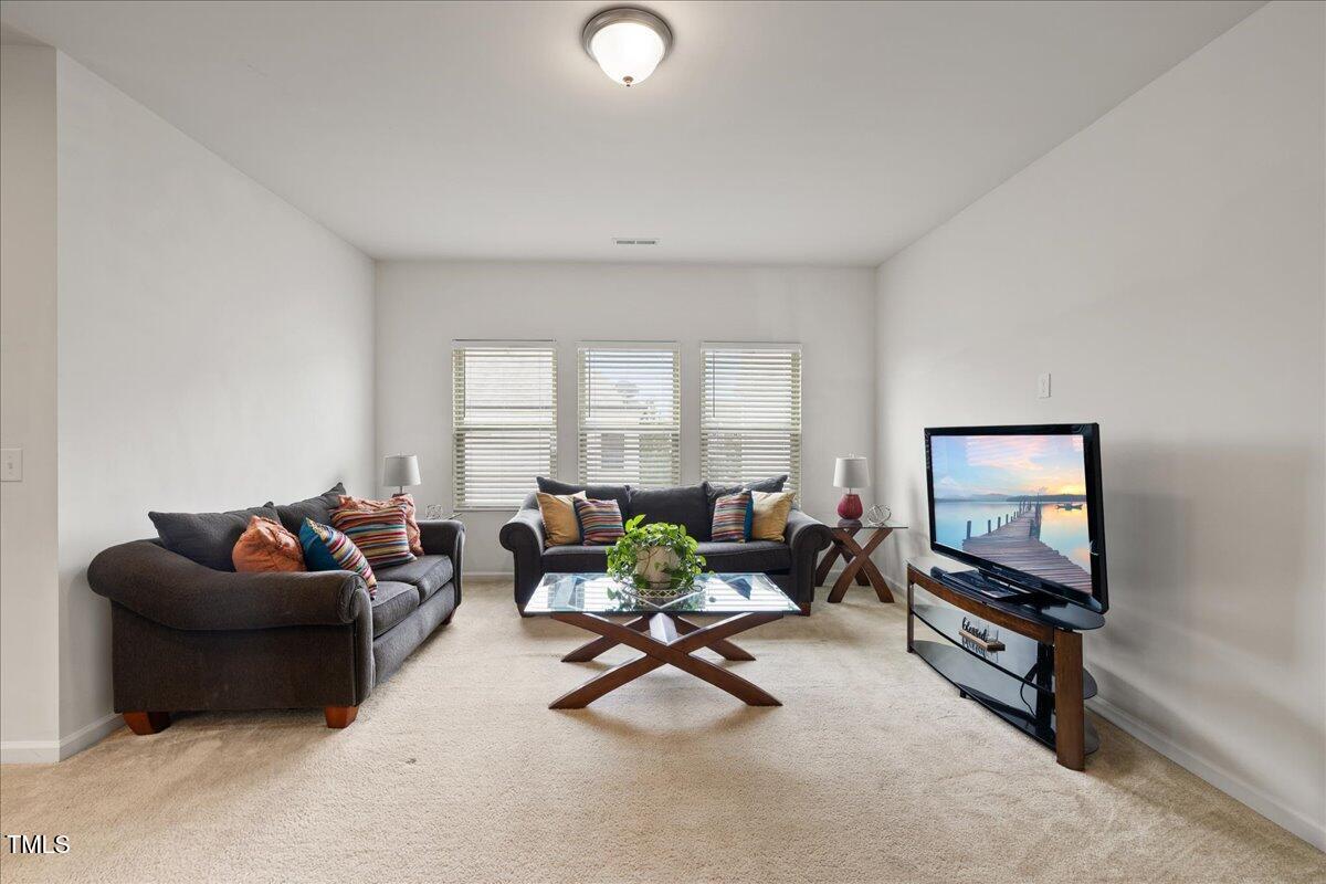 1610 Stone Road Durham, NC 27703 - Photo 11 of 40 a living room with furniture a window and a flat screen tv