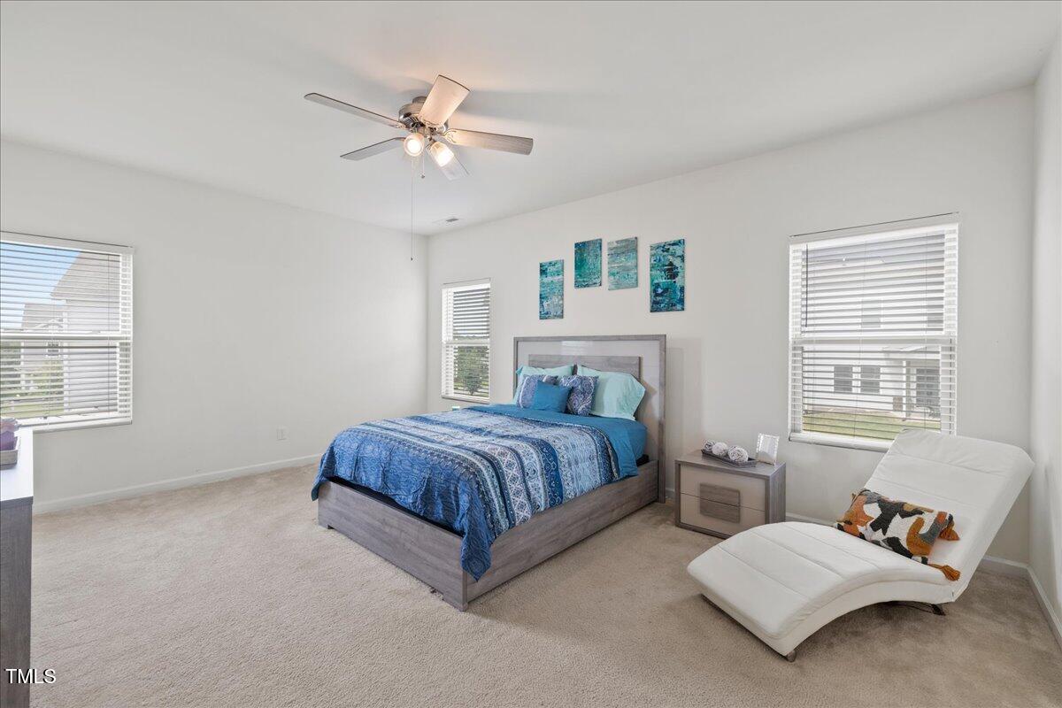 1610 Stone Road Durham, NC 27703 - Photo 12 of 40 a spacious bedroom with a bed and a chandelier
