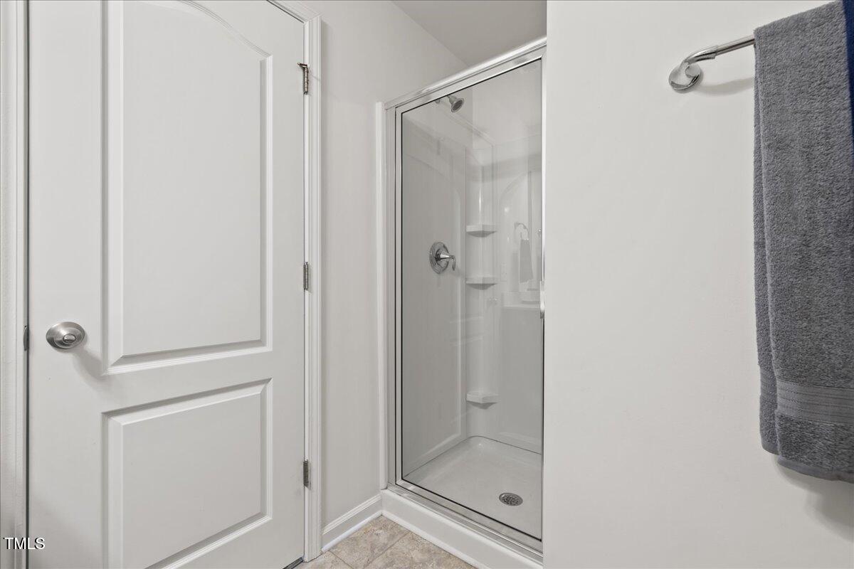 1610 Stone Road Durham, NC 27703 - Photo 24 of 40 a bathroom with a glass shower door