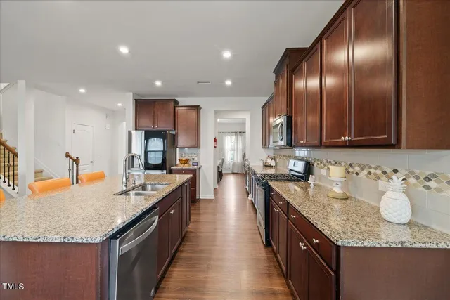 a large kitchen with granite countertop lots of counter space and stainless steel appliances
