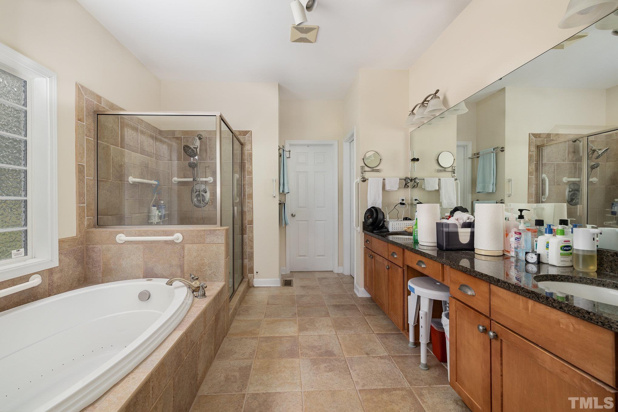 306 Few Circle Durham, NC 27705 - Photo 15 of 28 a large bathroom with a double vanity sink a mirror a bathtub and next to a window