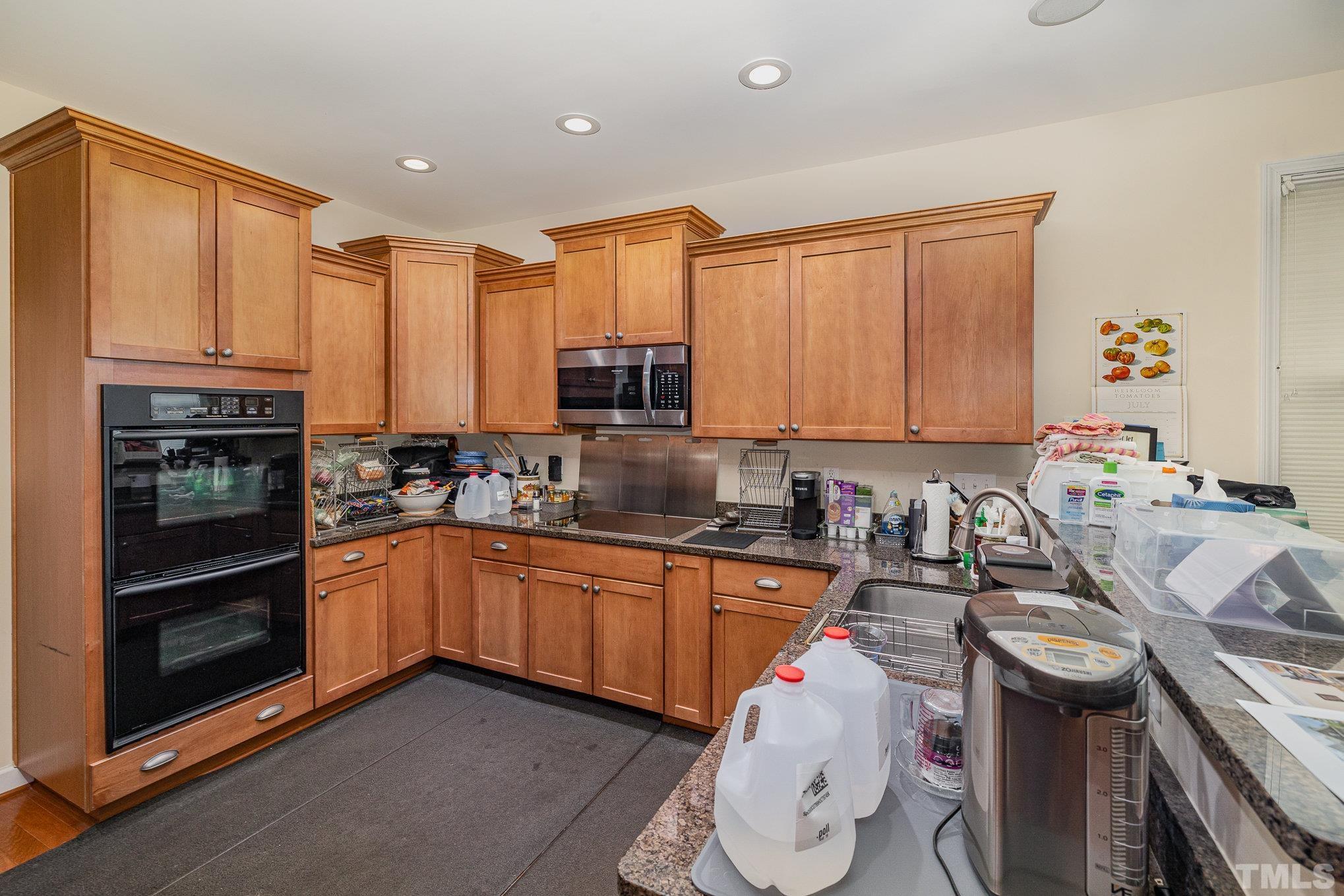 306 Few Circle Durham, NC 27705 - Photo 10 of 28 a kitchen with stainless steel appliances a sink a stove a refrigerator cabinets and a window