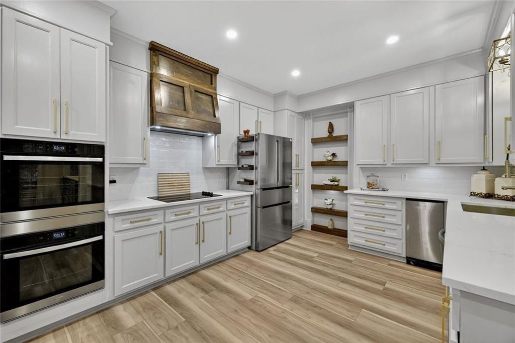 2525 Spalding Drive Atlanta, GA 30350 - Photo 22 of 58 a kitchen with stainless steel appliances granite countertop a stove top oven a sink dishwasher and a refrigerator with white cabinets