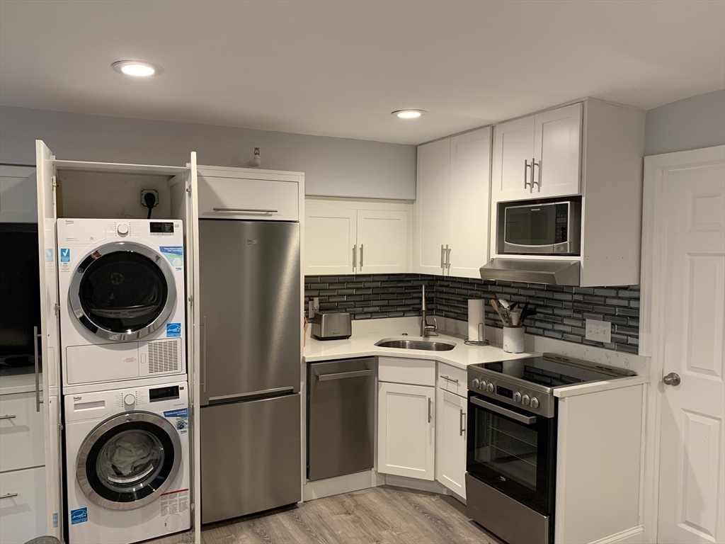 122 Beacon Street, Unit 1 Boston, MA 02116 - Photo 3 of 5 a kitchen with a stove sink and refrigerator
