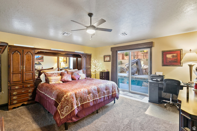 210 Talon Court Ivins, UT 84738 - Photo 26 of 60 Bedroom with a textured ceiling, access to outside, light carpet, an office area, and a ceiling fan