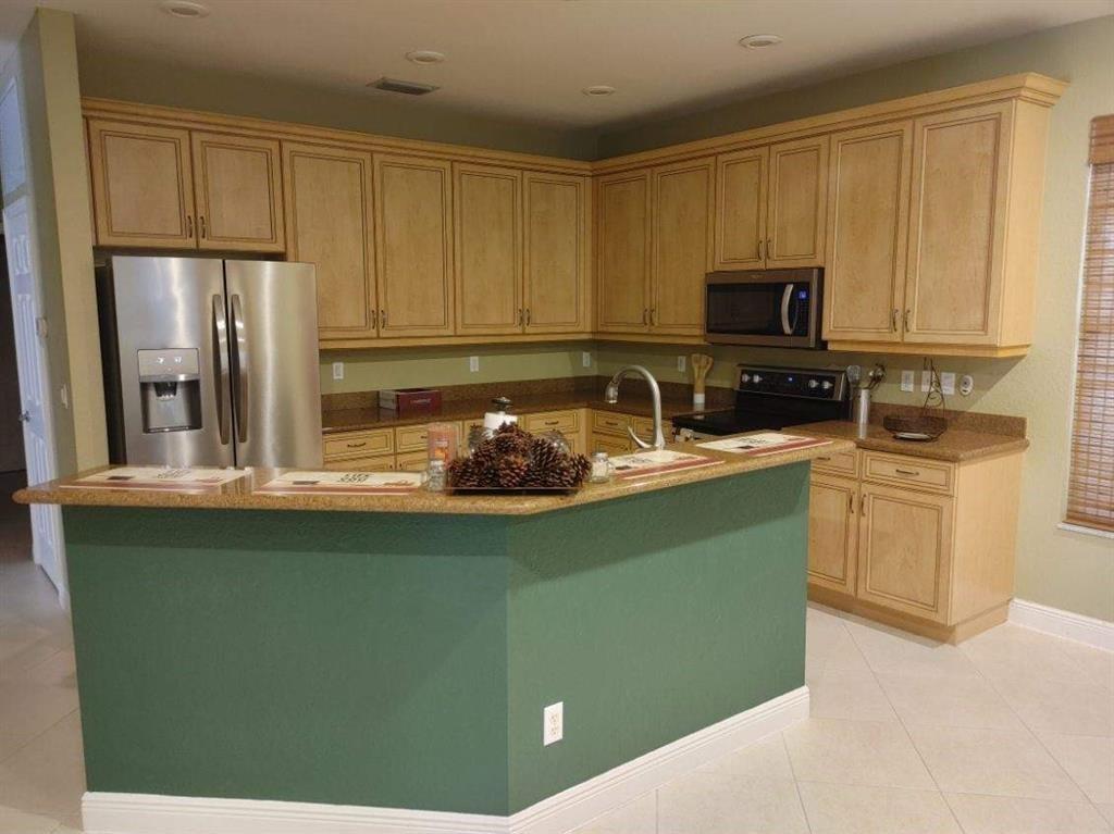 2009 Grey Falcon Circle Southwest Vero Beach, FL 32962 - Photo 5 of 9 a kitchen with a sink a stove and refrigerator