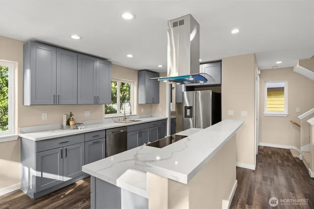 a kitchen with stainless steel appliances granite countertop a sink a stove a refrigerator and a refrigerator