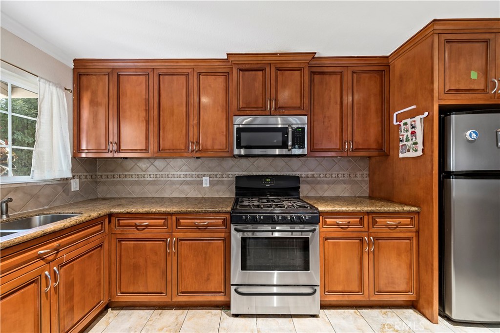 3524 Whitingham Drive West Covina, CA 91792 - Photo 10 of 39 a kitchen with granite countertop a stove top oven microwave and cabinets