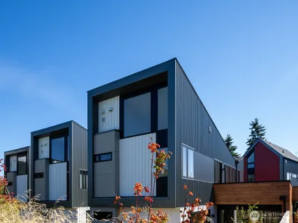 a view of swimming pool with seating area and trees in the background