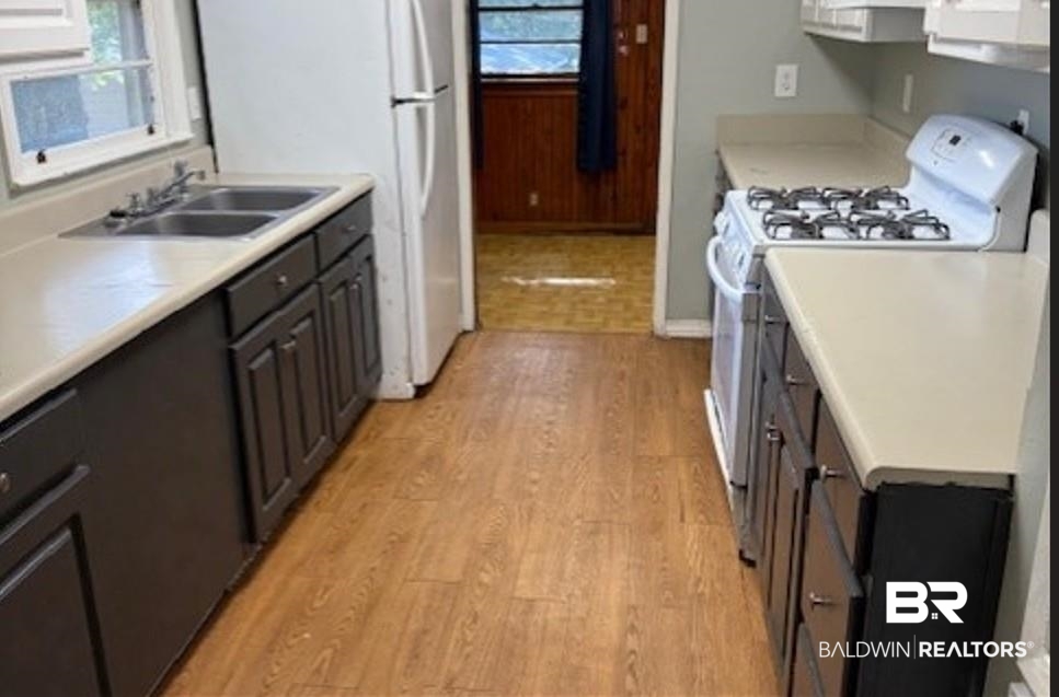 1809 Harris Road Mobile, AL 36618 - Photo 6 of 11 Kitchen with white appliances, light wood-type flooring, and light countertops