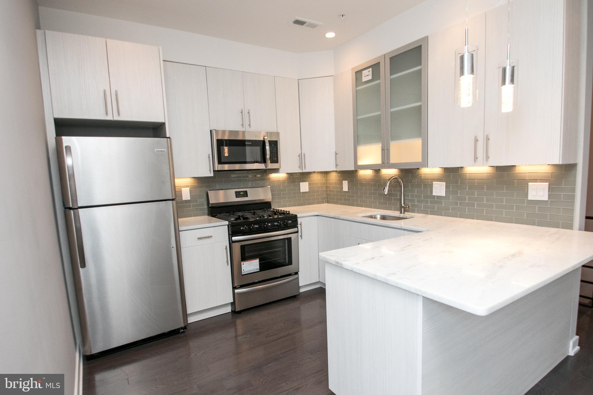 755 North Capitol Street Philadelphia, PA 19130 - Photo 14 of 47 a kitchen with granite countertop a refrigerator stove and sink