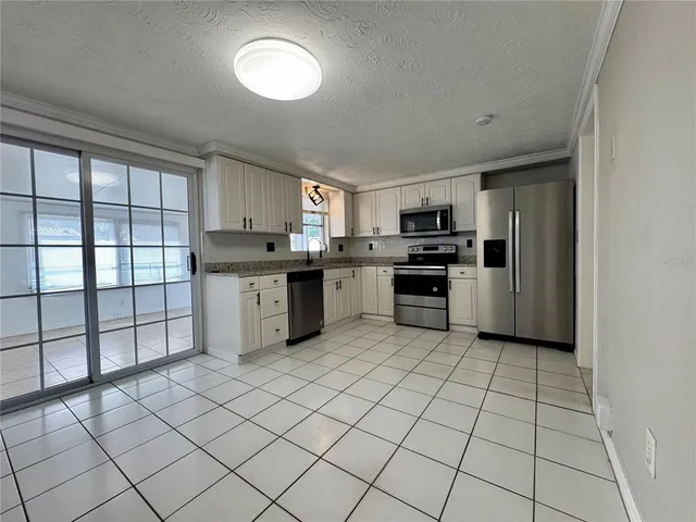 a kitchen with stainless steel appliances granite countertop a stove top oven a sink and a granite counter top