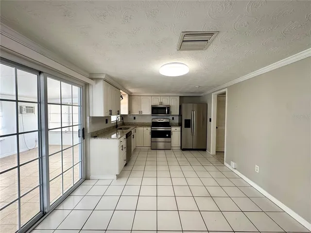 a kitchen with a sink a stove top oven and cabinets
