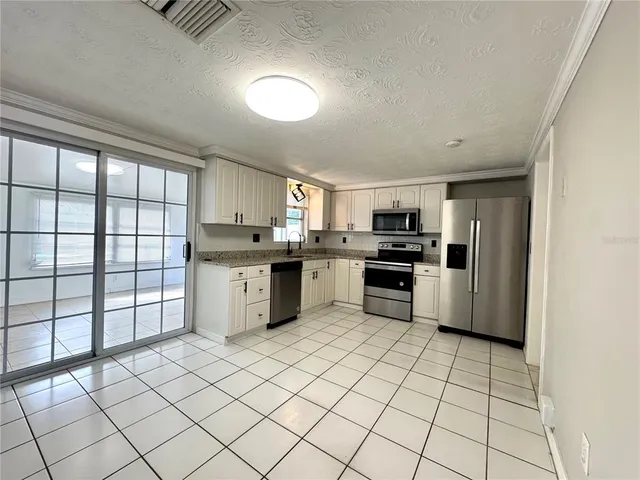 a kitchen with stainless steel appliances granite countertop a stove a sink and a refrigerator