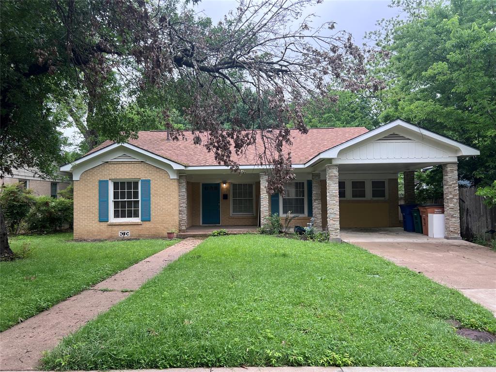 a front view of a house with a yard and trees
