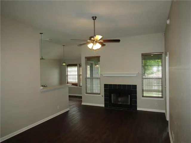wooden floor fireplace and windows in an empty room