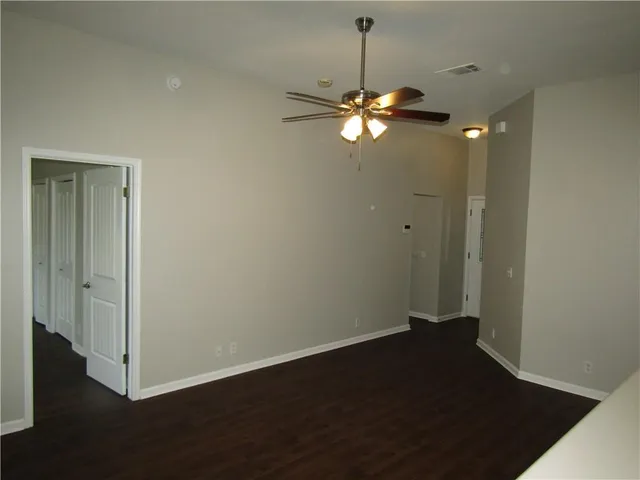 a view of a room with wooden floor and ceiling fan