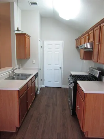 a kitchen with a sink stove top oven and cabinets
