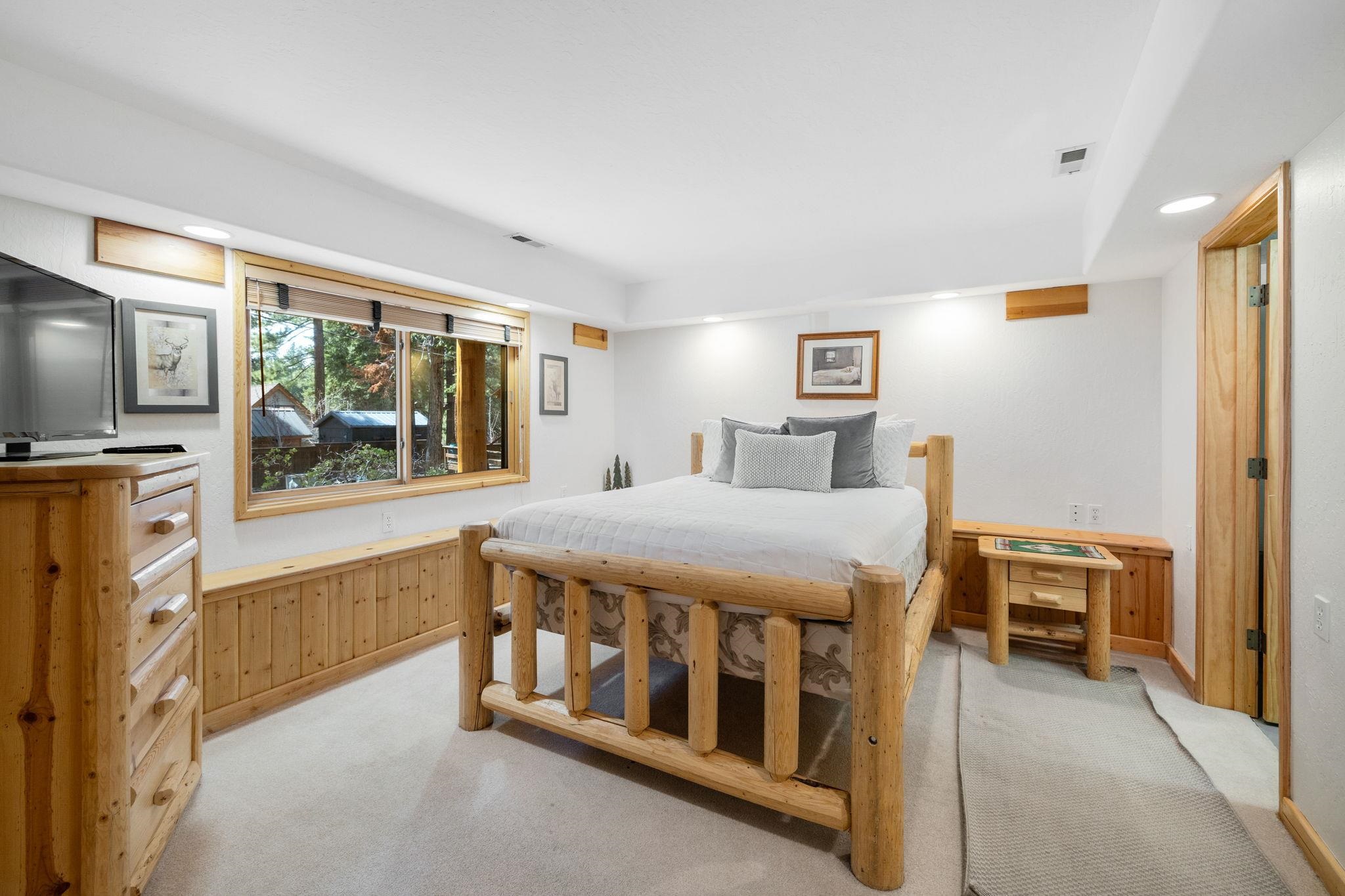 7883 Mashie Avenue Tahoe Vista, CA 96148 - Photo 22 of 28 a spacious bedroom with a bed and a large window