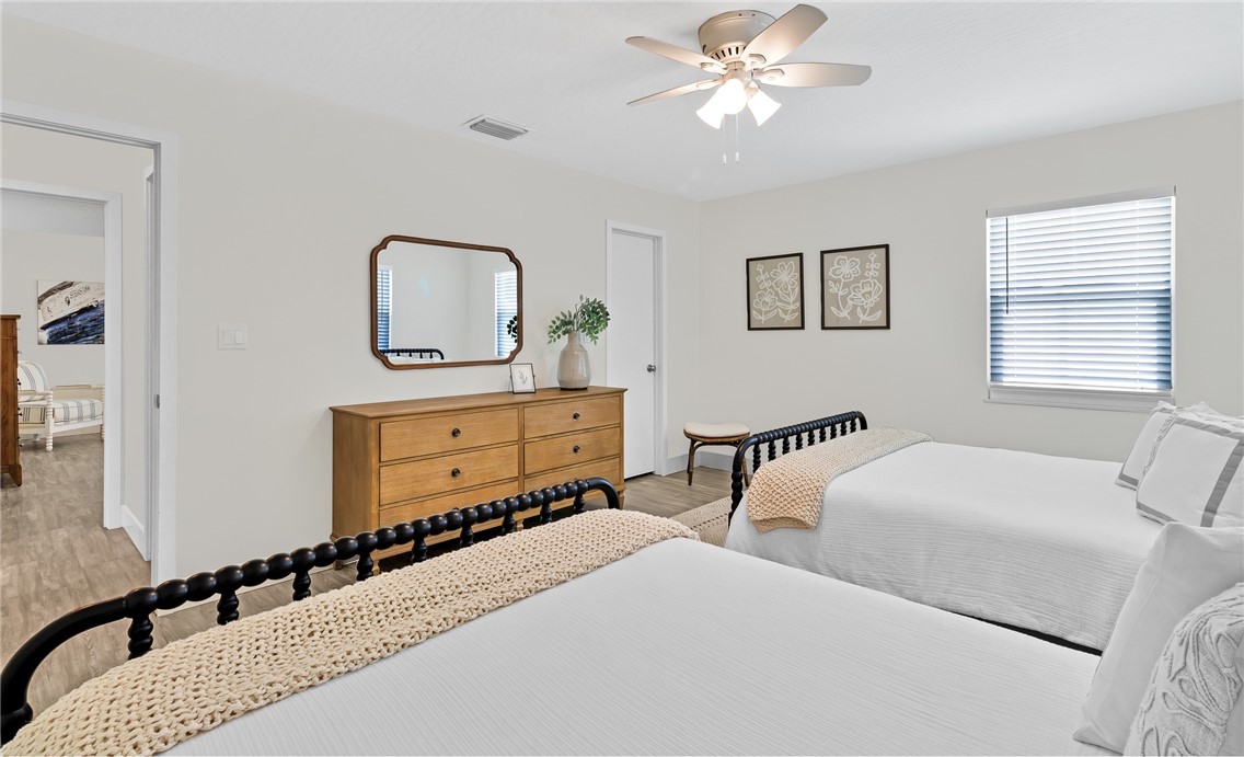 7989 143rd Street Sebastian, FL 32958 - Photo 17 of 30 a bedroom with two beds and a chandelier