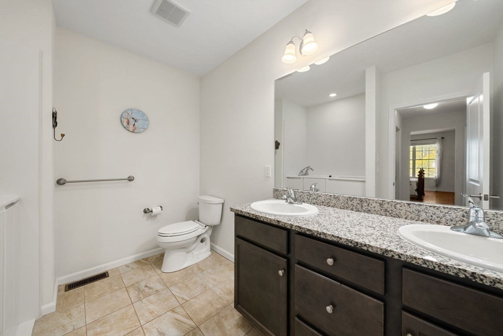 44 Mariners Way, Unit 44 Plymouth, MA 02360 - Photo 20 of 36 a bathroom with a granite countertop sink a toilet and a mirror