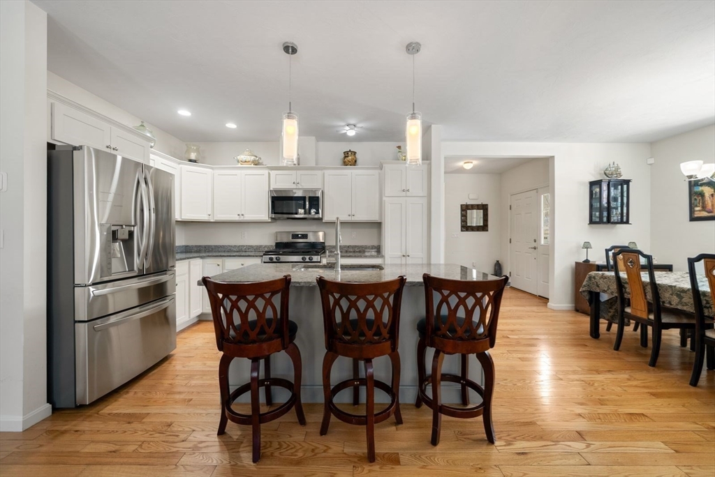 44 Mariners Way, Unit 44 Plymouth, MA 02360 - Photo 6 of 36 a kitchen with stainless steel appliances granite countertop a dining table chairs refrigerator and sink