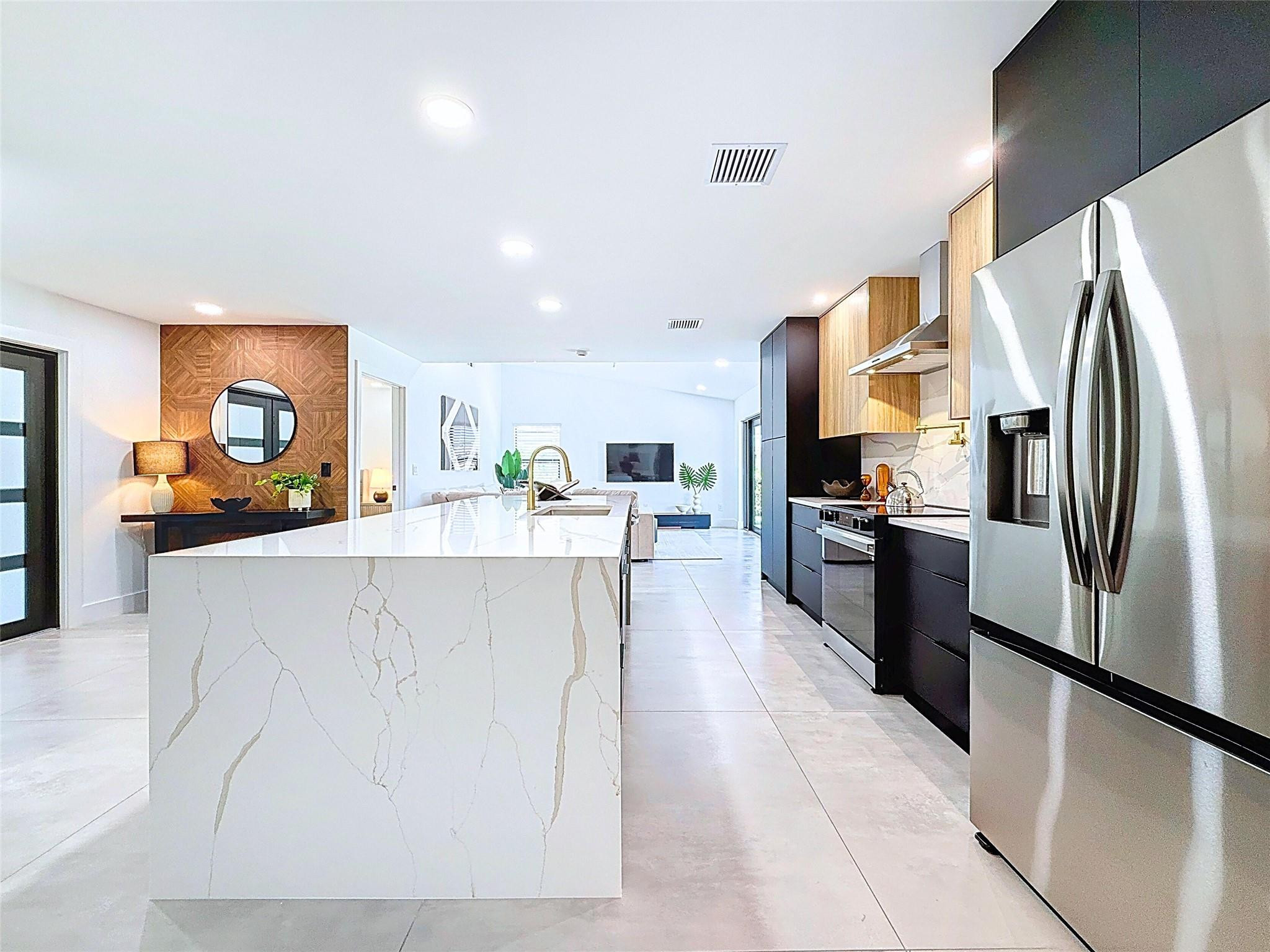 17732 Briar Patch Trail Boca Raton, FL 33487 - Photo 8 of 27 a view of kitchen with kitchen island a counter top space a refrigerator wooden floor and a view of living room