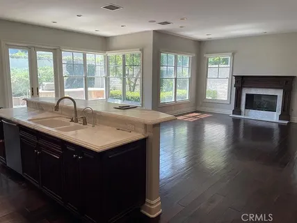 a kitchen with a sink a window and wooden floor