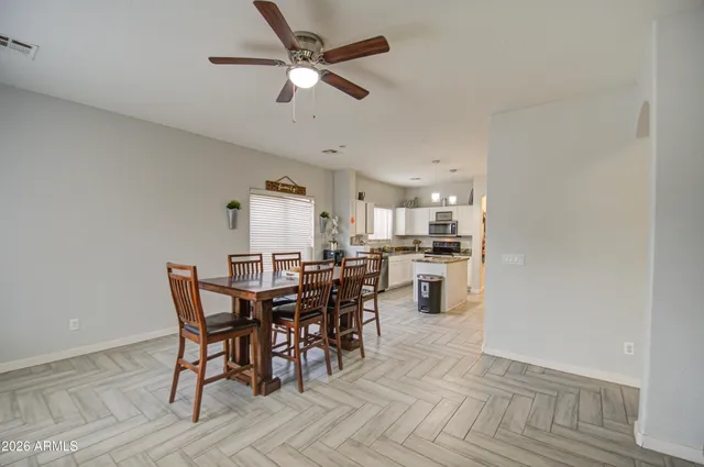 a view of a dining room and livingroom with furniture wooden floor a rug a fireplace