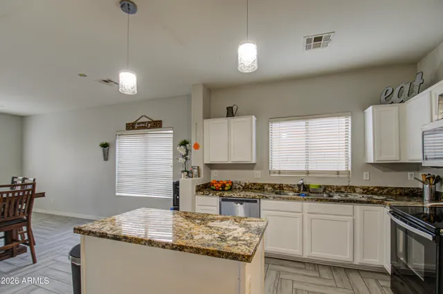 a kitchen with stainless steel appliances granite countertop a sink stove and cabinets