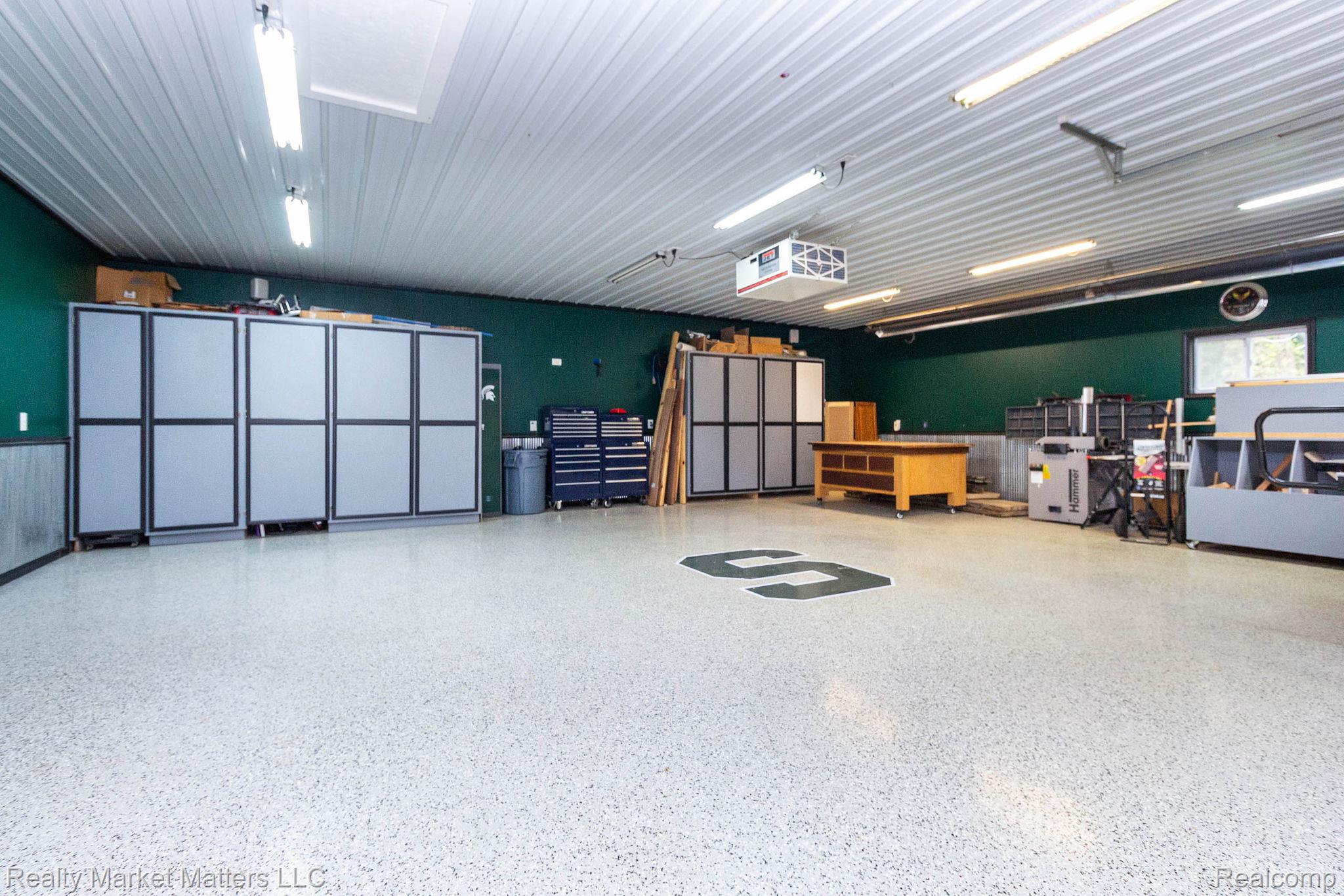 770 North Fairgrounds Road Imlay City, MI 48444 - Photo 33 of 55 Spacious garage with durable epoxy flooring, extensive built-in storage cabinetry, and ample overhead lighting