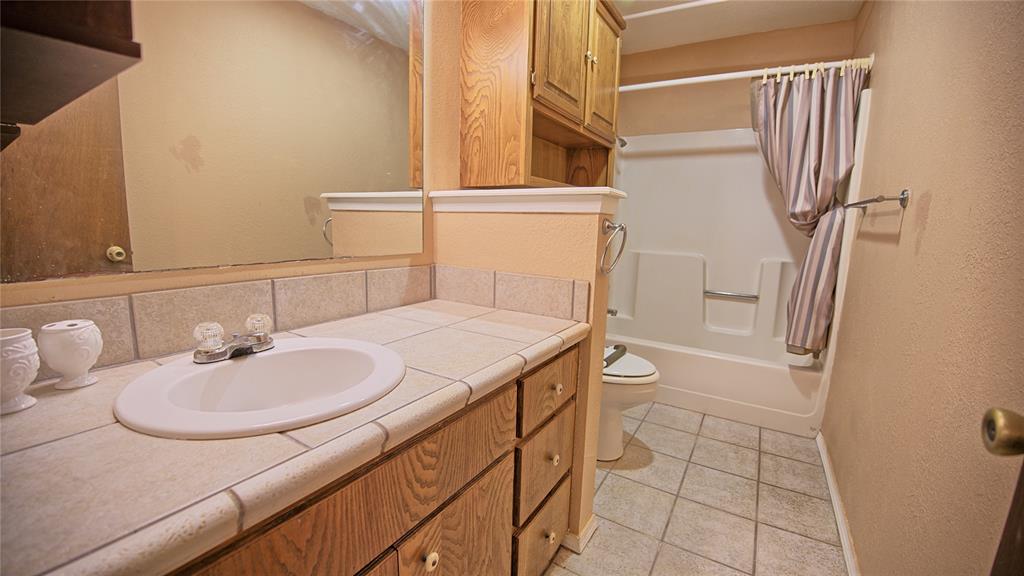 1740 Oakshores Road Nocona, TX 76255 - Photo 18 of 38 a bathroom with a sink toilet and shower
