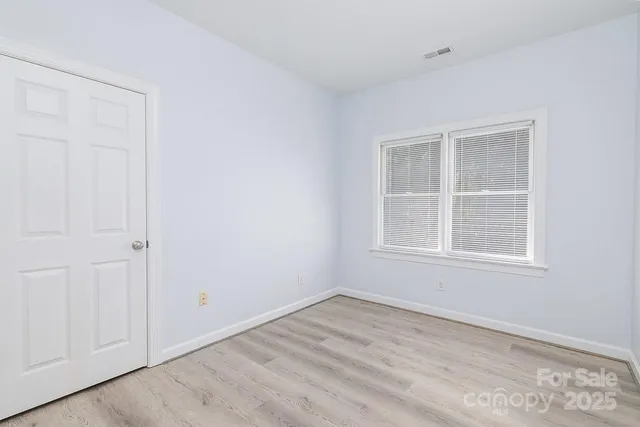 an empty room with a window and a ceiling fan