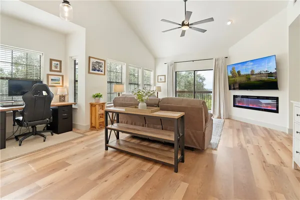 a living room with furniture a flat screen tv and a floor to ceiling window