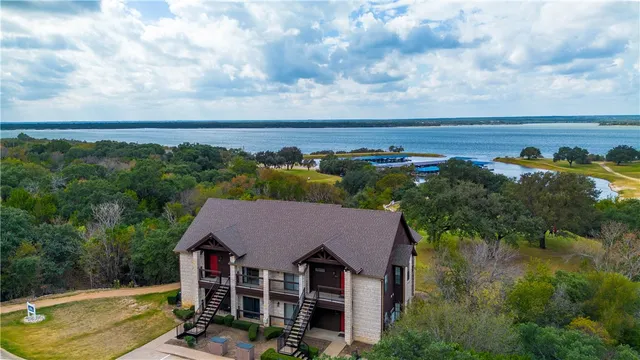 an aerial view of a house with swimming pool and lake view