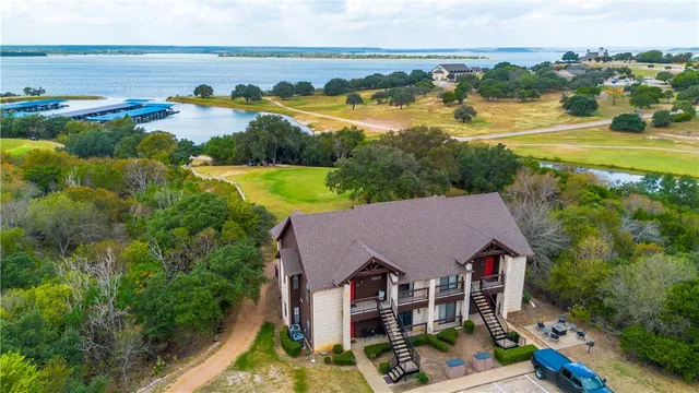 an aerial view of residential houses with outdoor space and ocean view