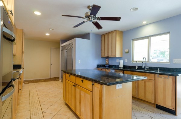 7935 Ulili Road Kekaha, HI 96752 - Photo 7 of 20 a kitchen with granite countertop a sink appliances cabinets and a large window