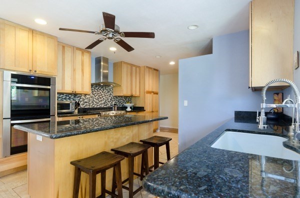 7935 Ulili Road Kekaha, HI 96752 - Photo 8 of 20 a kitchen with granite countertop a table chairs microwave and sink