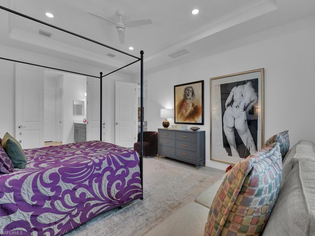 7229 Wiregrass Court Naples, FL 34114 - Photo 17 of 40 a bedroom with a large bed and a chandelier