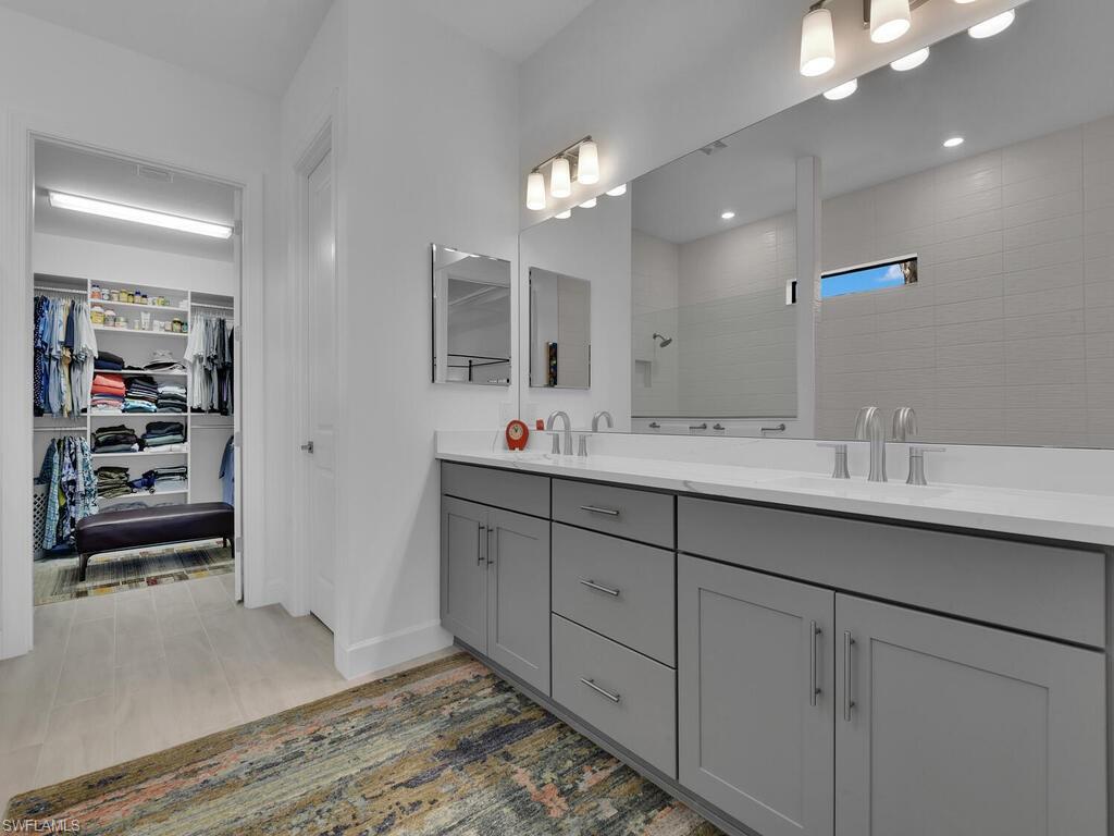 7229 Wiregrass Court Naples, FL 34114 - Photo 19 of 40 a bathroom with a sink double vanity and a mirror