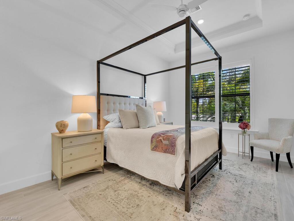 7229 Wiregrass Court Naples, FL 34114 - Photo 20 of 40 a bedroom with a bed and a mirror