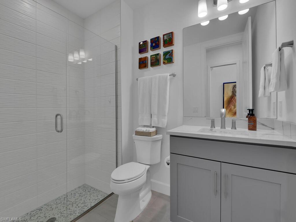 7229 Wiregrass Court Naples, FL 34114 - Photo 21 of 40 a bathroom with a sink a toilet and shower