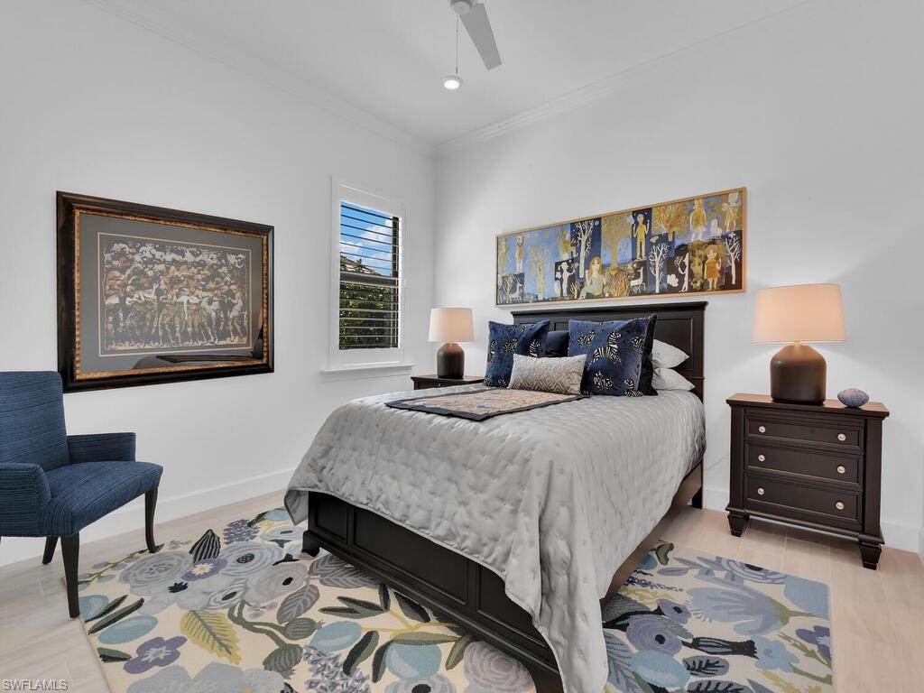 7229 Wiregrass Court Naples, FL 34114 - Photo 22 of 40 a bedroom with a bed and wooden floor
