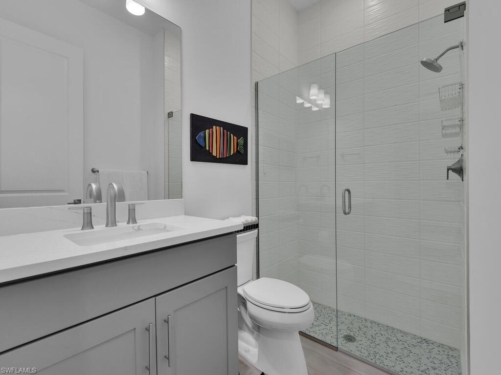 7229 Wiregrass Court Naples, FL 34114 - Photo 23 of 40 a bathroom with a sink a toilet and shower