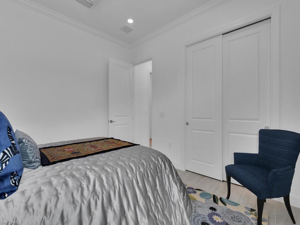 7229 Wiregrass Court Naples, FL 34114 - Photo 24 of 40 a bedroom with a bed and a chair