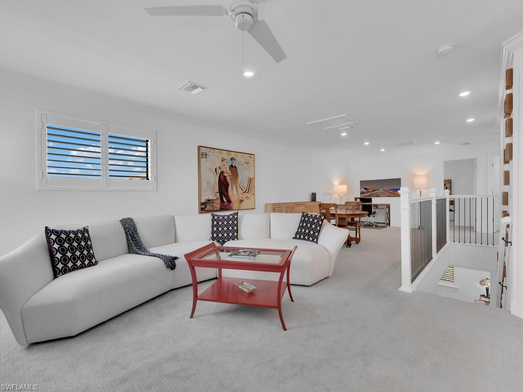 7229 Wiregrass Court Naples, FL 34114 - Photo 25 of 40 a living room with furniture and a book shelf